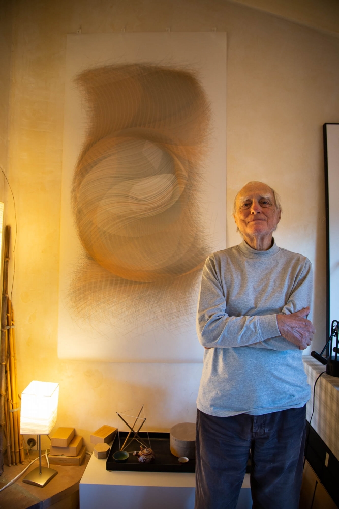 Jean-Pierre Hebert stands in his parlor next to one of his plotted art pieces.