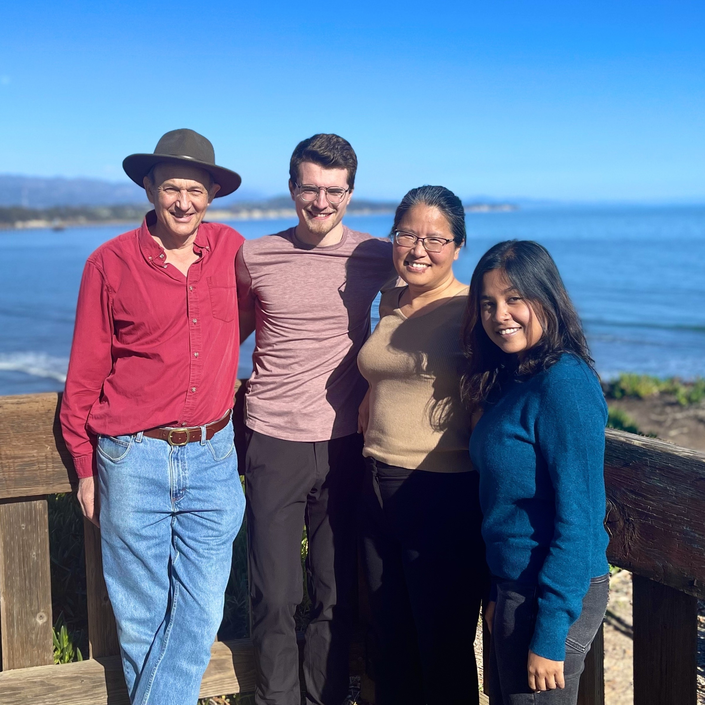 Four of the authors standing in front of the ocean.
