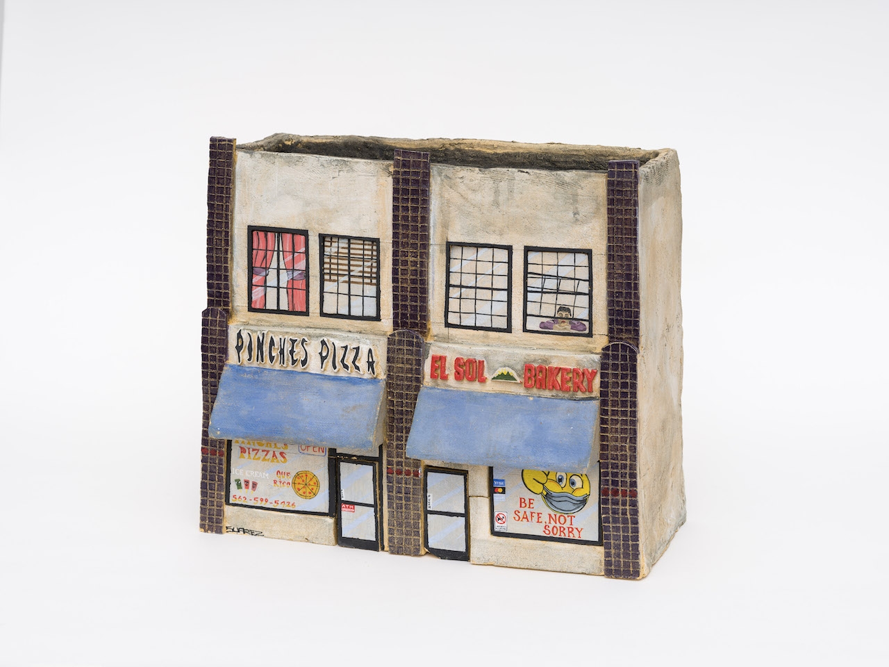 Ceramic reproduction of a storefront building with Pinche's Pizza.