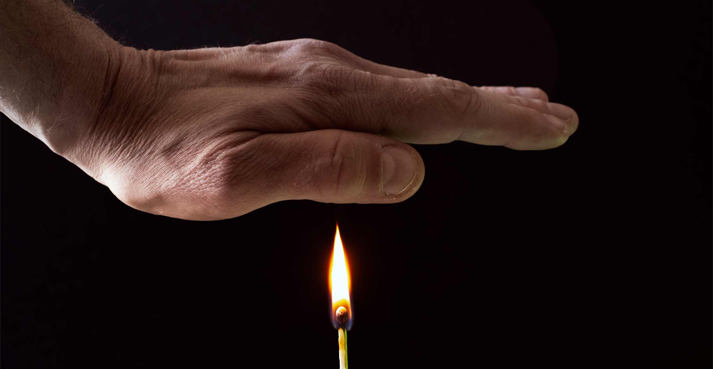 A hand hovering over a match