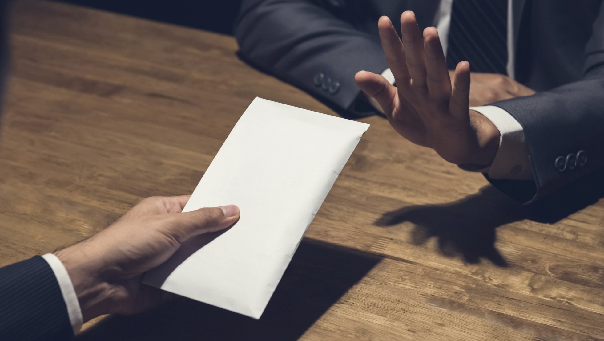 man refusing envelope of cash