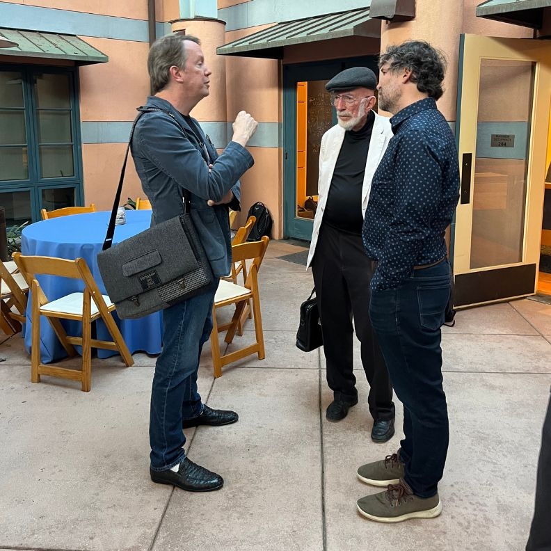 Sean Carroll, Kip Thorne and Daniel Holz talk in Kohn Hall courtyard.