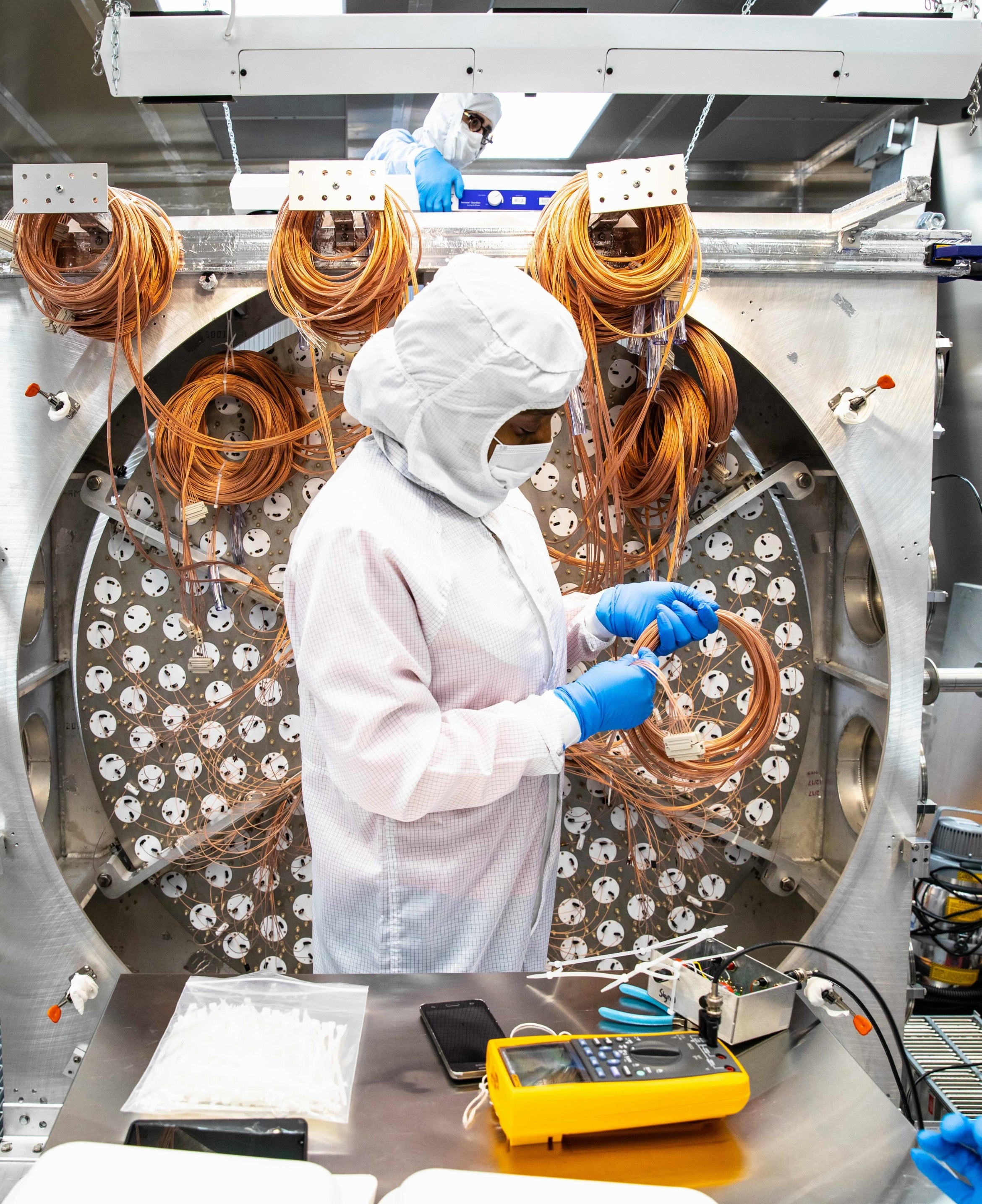 a researcher clipping cables for dark matter detection equipment